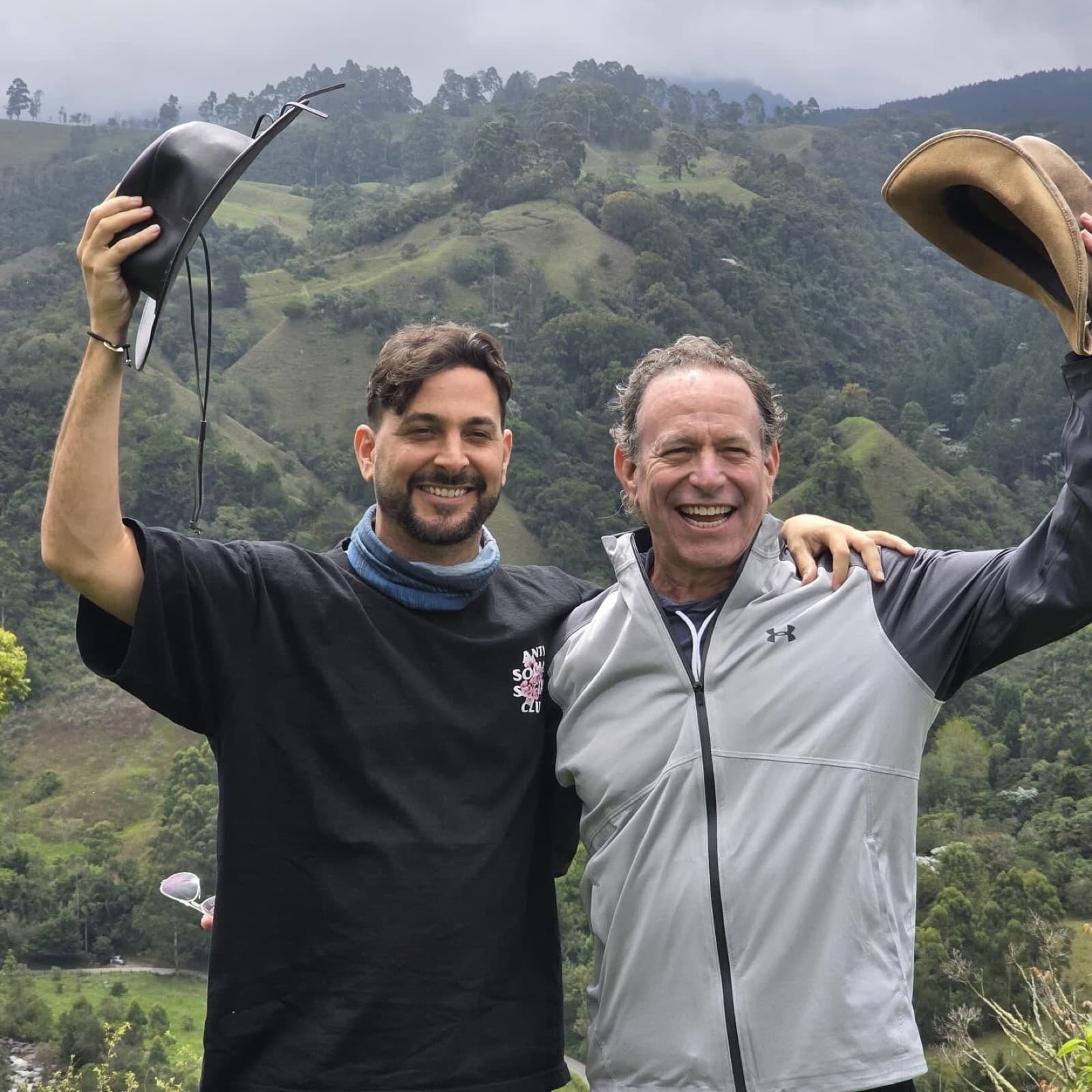 A father and son celebrating on a mountain excursion